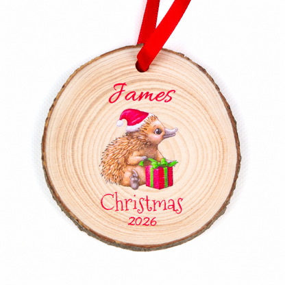 Personalised echidna Christmas 2026 wood slice ornament with red ribbon on a white background.
