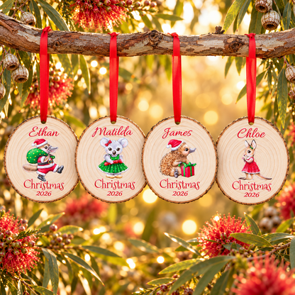 Four personalised Australian Christmas wood slice ornaments for 2026: platypus, koala, echidna and kangaroo hanging on red ribbons from a eucalyptus branch