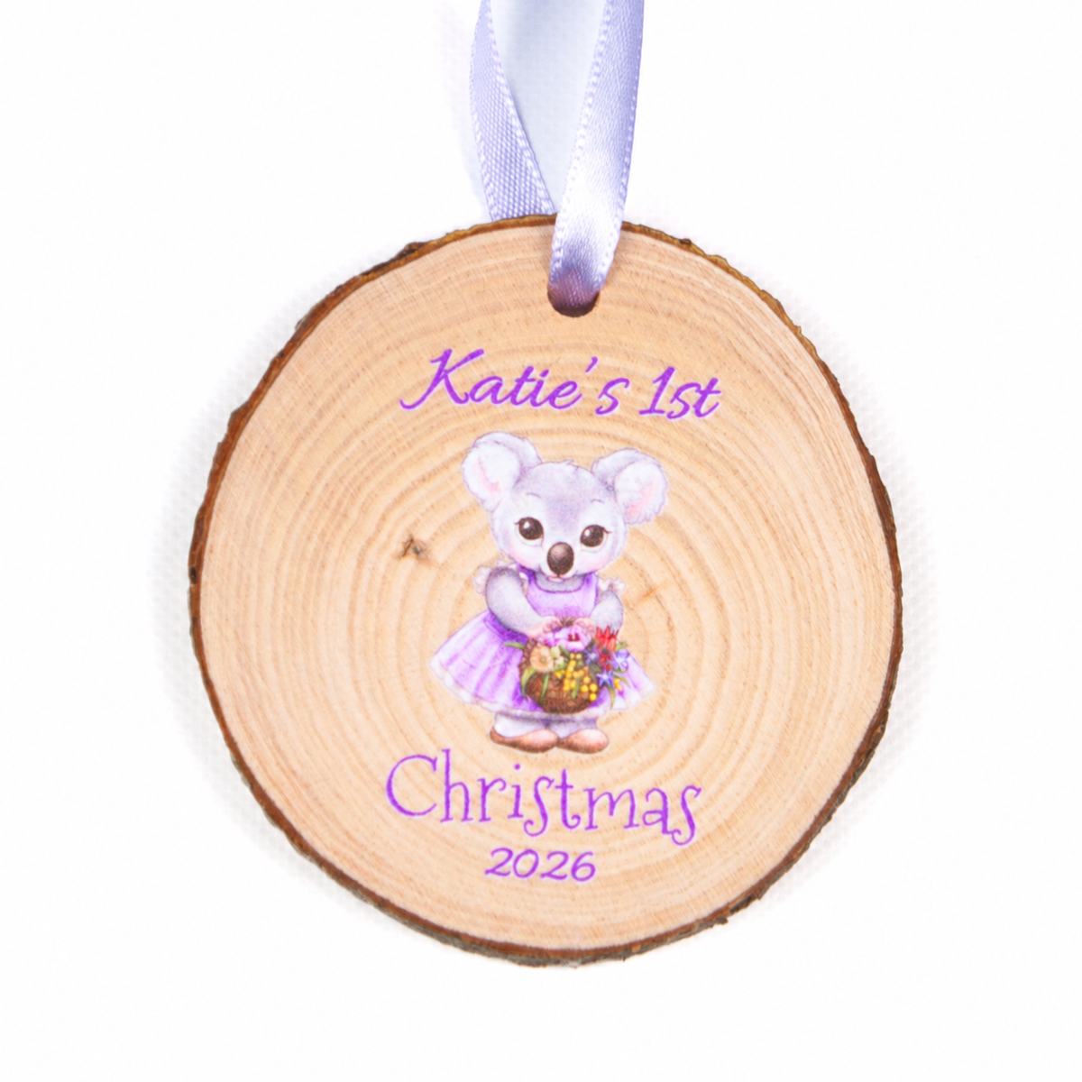 Personalised koala first Christmas 2026 wood slice ornament with purple ribbon on a white background.