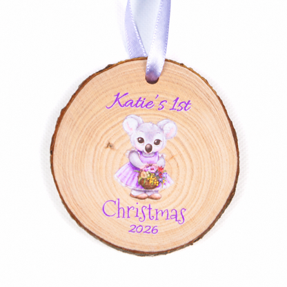 Personalised koala first Christmas 2026 wood slice ornament with purple ribbon on a white background.